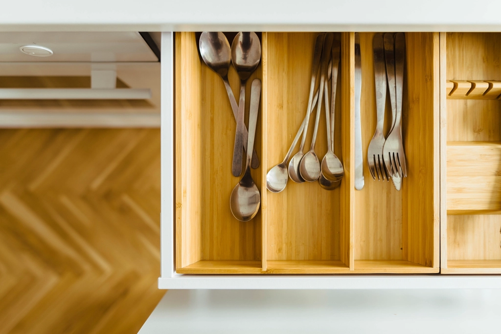 Close-up of a wood drawer with fitted cutlery dividers